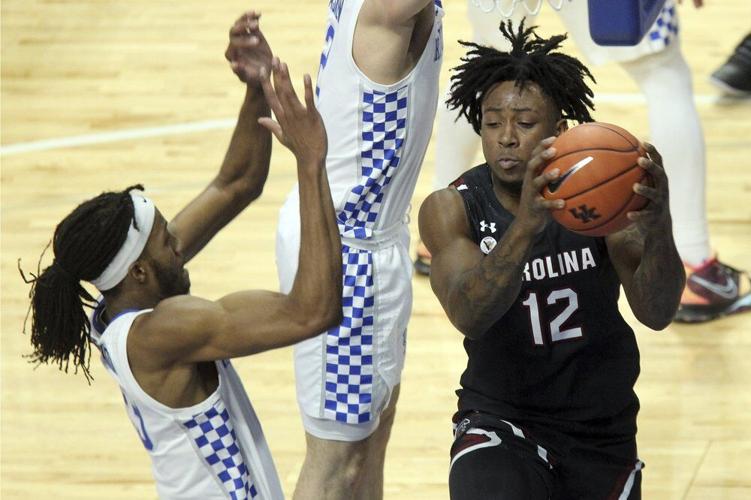 South Carolina's Trae Hannibal (12) looks for help as Kentucky's Isaiah Jackson defends