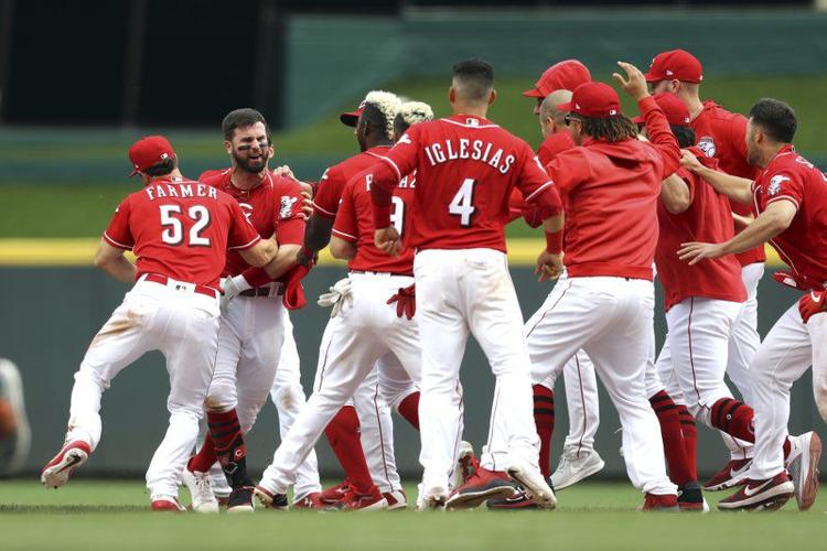 Jesse Winker, left, celebrates with teammates