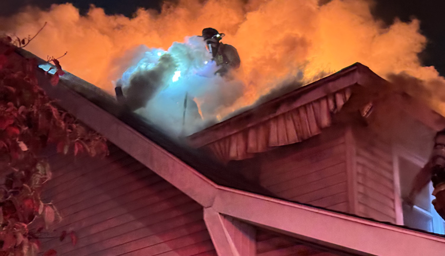 Louisville fire crews on roof of burning home