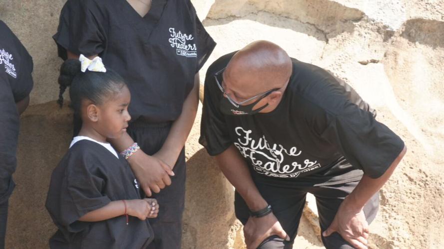 Christopher 2X talks with young girl in Future Healers Got Zoo Buddies program