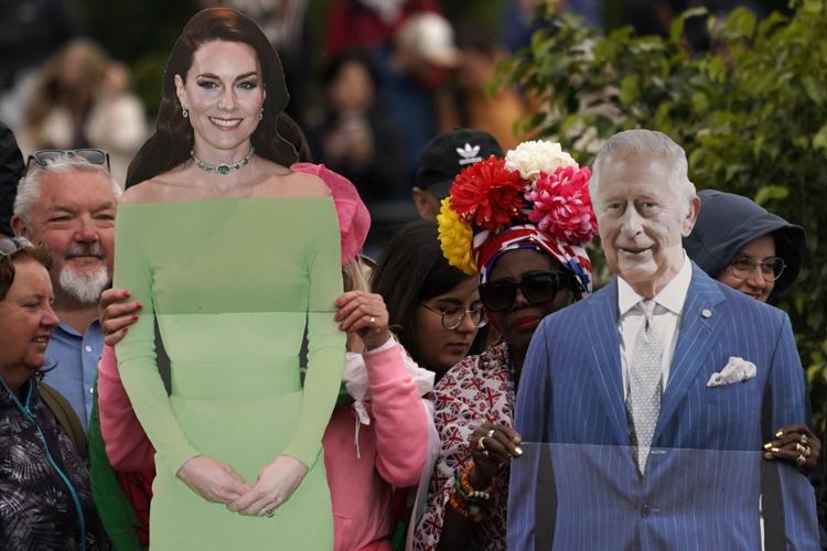 Royal fans hold up cut-out pictures of Britain's King Charles III, and Kate, Princess of Wales