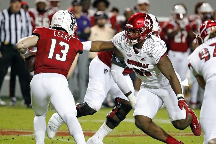 Louisville Derek Dorsey tries to tackle North Carolina State quarterback Devin Leary.jpeg