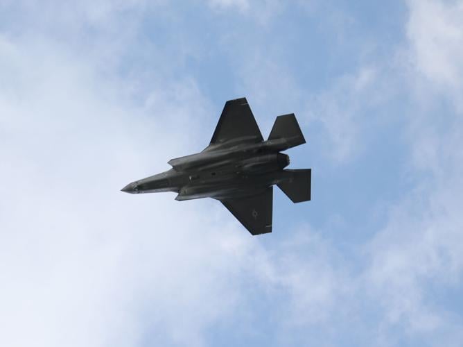 Plane flies during Air Show near river.JPG