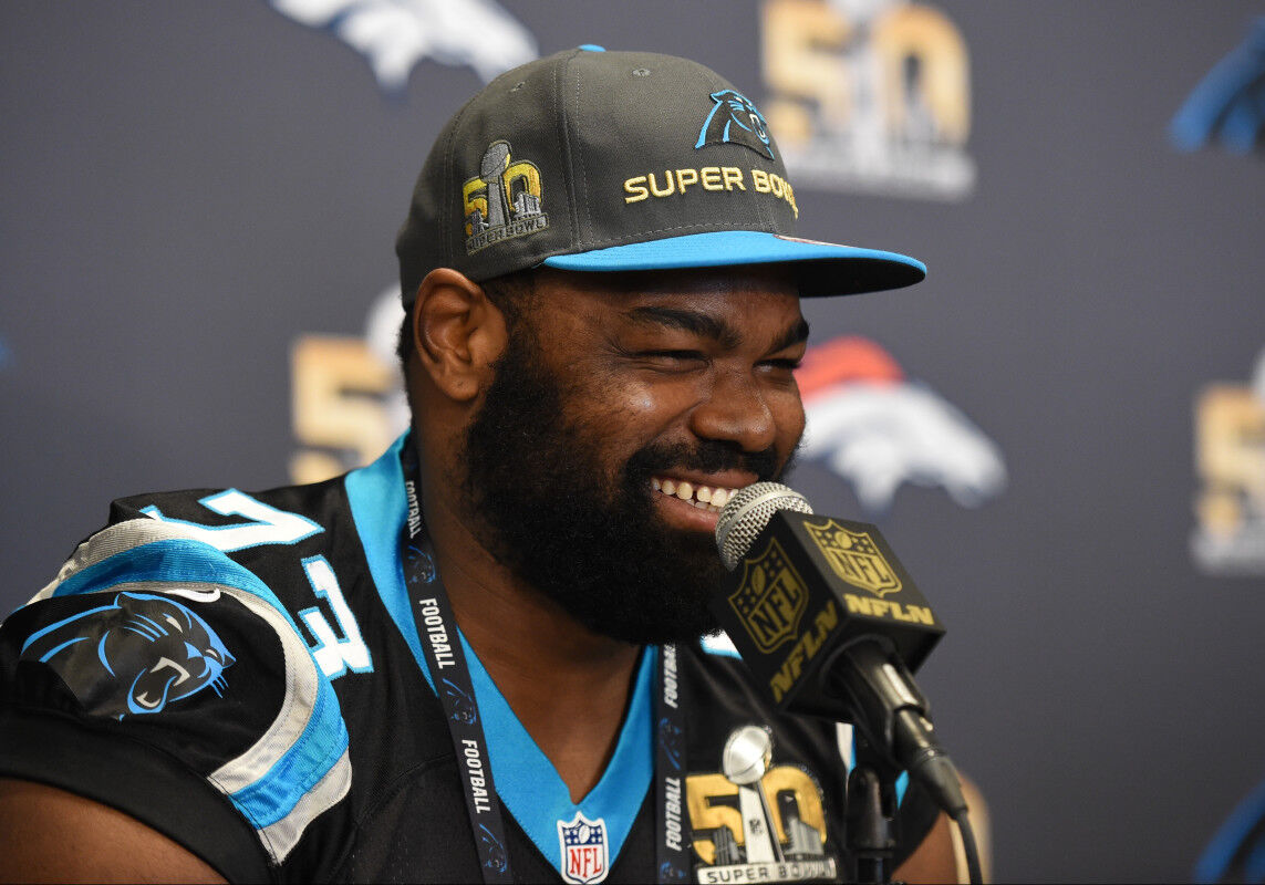 Michael Oher, a tackle from Mississippi, holds up a jersey after