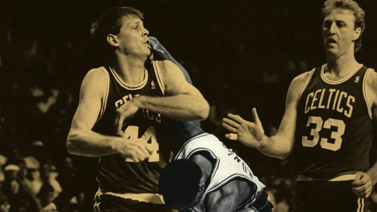 Danny Ainge holds up a Celtics jersey bearing his old number