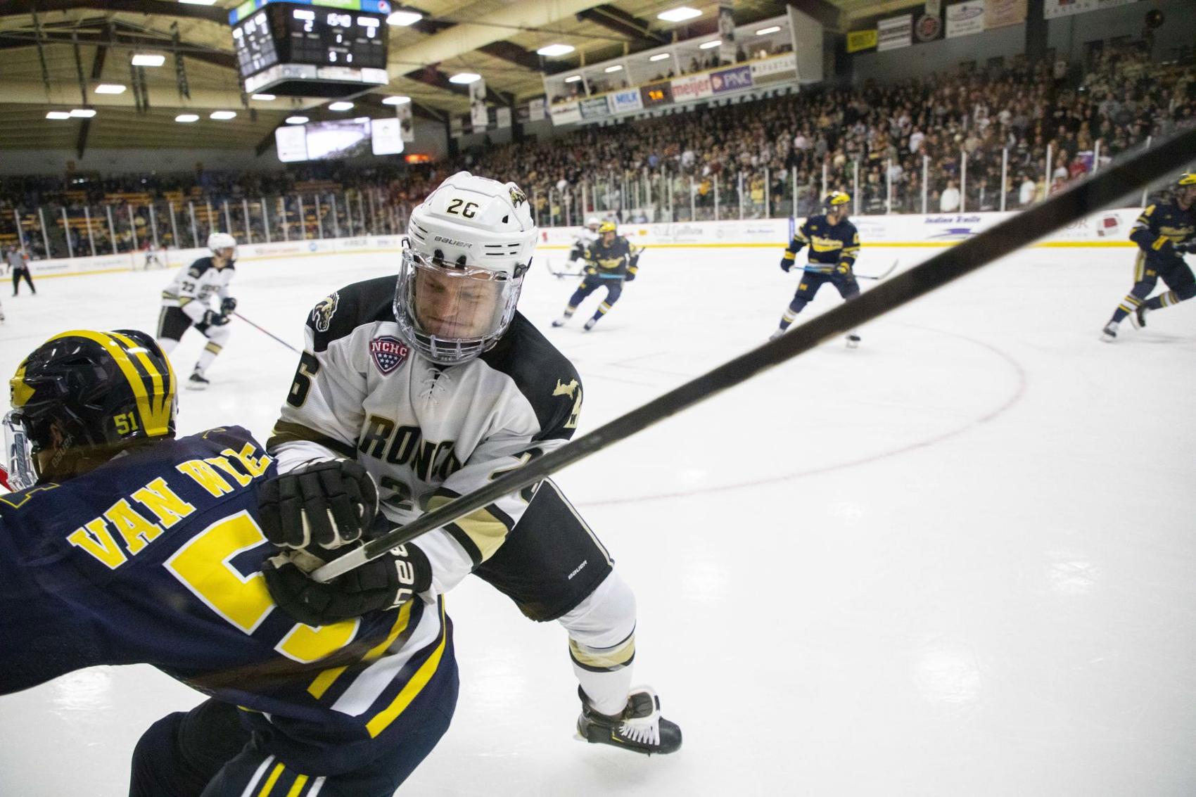 Ethan Frank checks a Michigan player in the first period