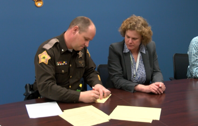 Sheriff Noah Robinson and Southwestern CEO Katy Adams sign the agreement