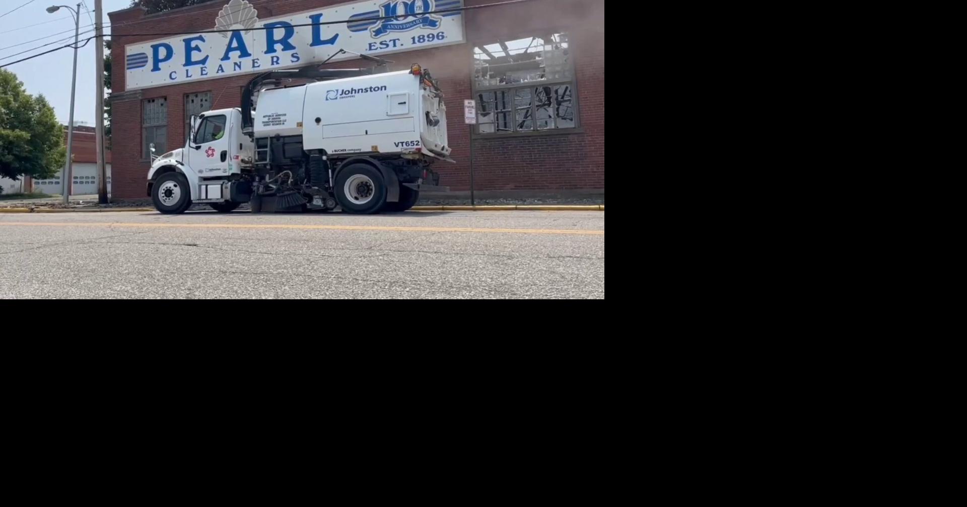 Street sweeper cleans up outside old Pearl Cleaners building after fire