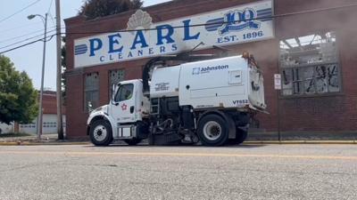Street sweeper cleaning up outside of old Pearl Cleaners building after it was destroyed by fire