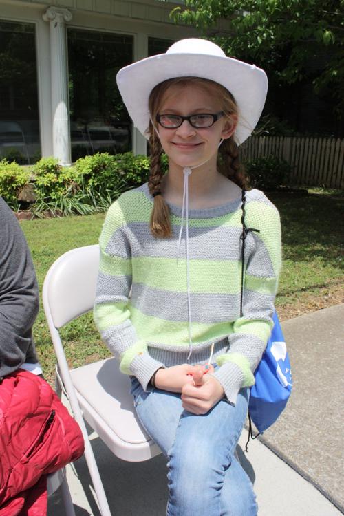 Sierra Fox grabs a seat on Bridge Street to watch the Rodeo Parade at high noon