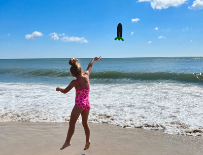 Shelby Howell of Leesburg, VA. Photo of child on beach throwing toy.
