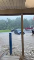 Flooding in Fairmont, West Virginia. People pushing vehicles out of water at Dairy Creme Corner.