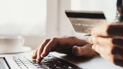 Man hand holding credit card and using laptop at home, Businessman or entrepreneur working, Online shopping, e-commerce, internet banking, spending money, working from home concept