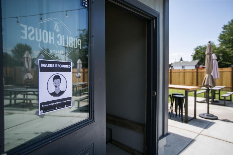 FILE — A sign taped to a doorway reads “Masks Required” at Public House of Yakima, 5703 Tieton Drive in Yakima, Wash., on Friday, July 3, 2020. 