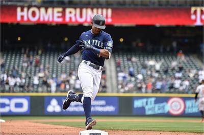 Julio Rodriguez of the Seattle Mariners tosses his bat during the