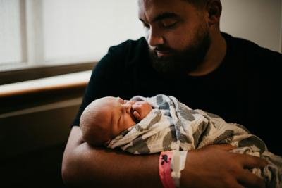 Newborn being held