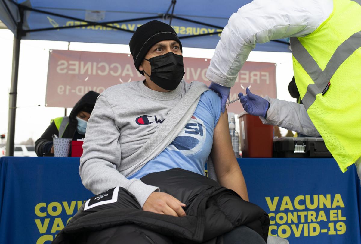 Jose Vargas receives a COVID-19 vaccine from a Columbia Safety employee in a parking lot.