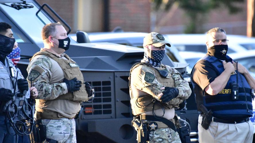 COVER-Alamance County sheriffs with armored vehicle protecting monument at Sept 2020 marcy by Tony Crider.jpg