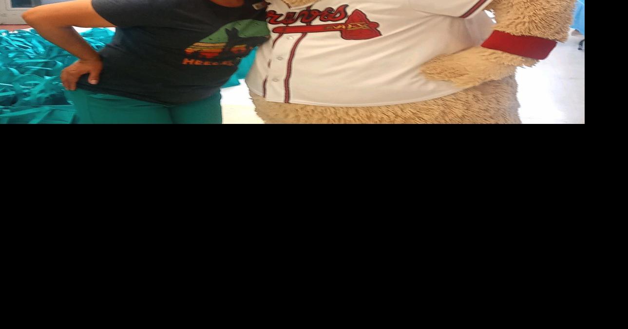 Michele Moore gets a hug from Blooper, the Atlanta Braves mascot