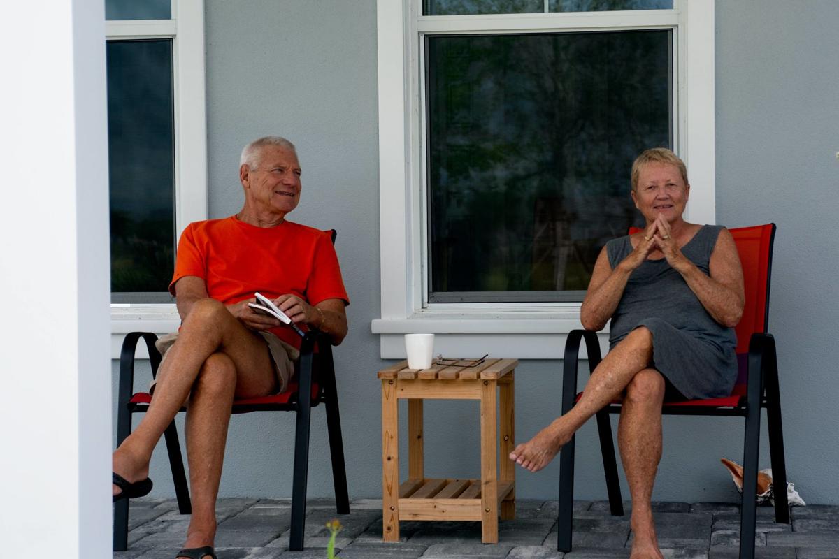 an older couple sits on the porch of a home at babcock ranch