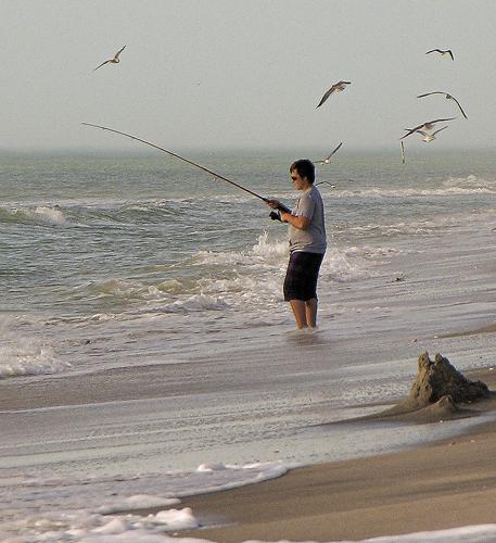 Three People Surf Fishing With One Fishing Pole At Cocoa Beach